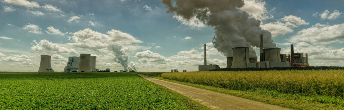 Installation industrielle polluante entourée de champs agricoles